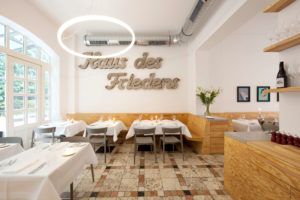 Restaurant-Ross Berlin mit Schriftzug Haus des Friedens und Designer Ringleuchte TheO