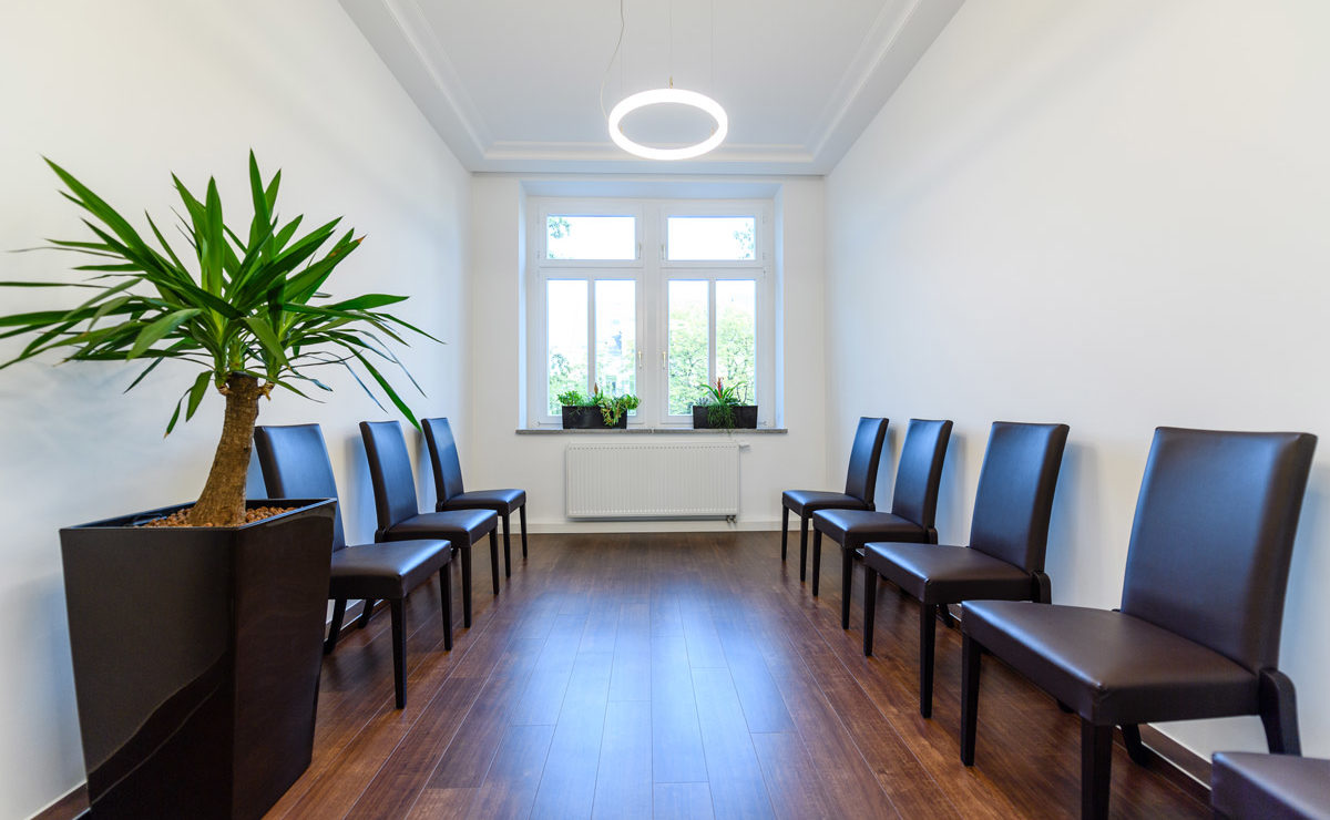 Wartezimmer Arzt mit Lederstühlen und kleiner LED-Ringleuchte an der Decke
